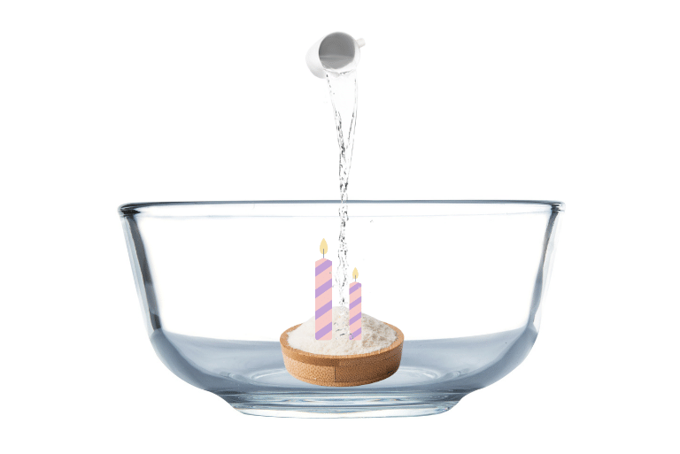 Dish containing baking soda and candle inside a bigger bowl.