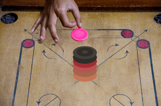 Hand about to hit the striker towards the pile.