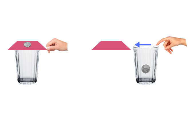 The stiff card covering an empty glass tumbler is given a sharp horizontal flick with a finger.